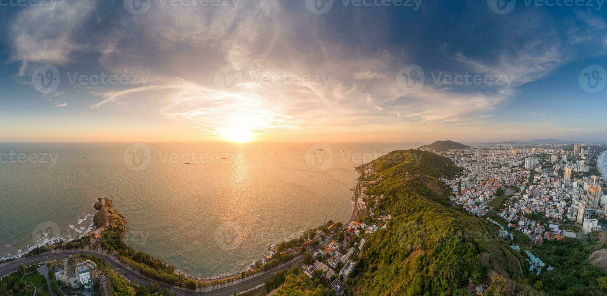 Panoramic coastal Vung Tau view from above, with waves, coastline, streets, coconut trees, Mount Nho in Vietnam behind the statue of Christ the King photo