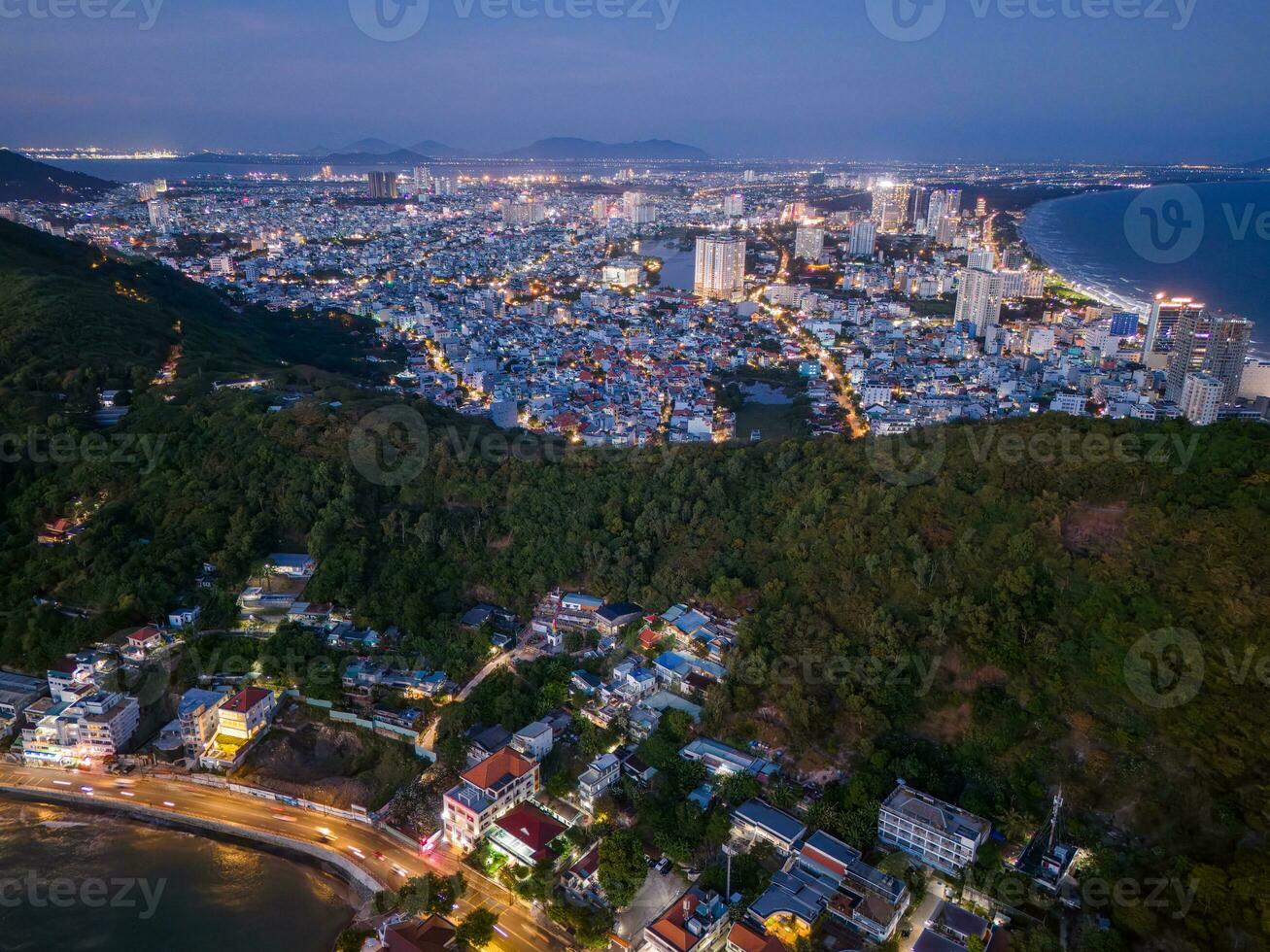 Panoramic coastal Vung Tau view from above, with waves, coastline, streets, coconut trees, Mount Nho in Vietnam behind the statue of Christ the King photo