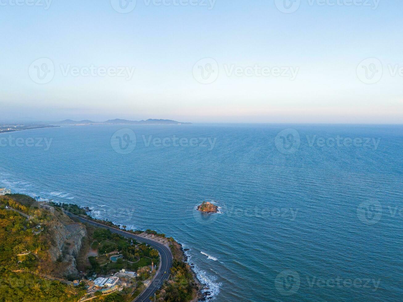 Panoramic coastal Vung Tau view from above, with waves, coastline, streets, coconut trees, Mount Nho in Vietnam behind the statue of Christ the King photo