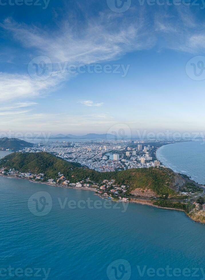 Panoramic coastal Vung Tau view from above, with waves, coastline, streets, coconut trees, Mount Nho in Vietnam behind the statue of Christ the King photo