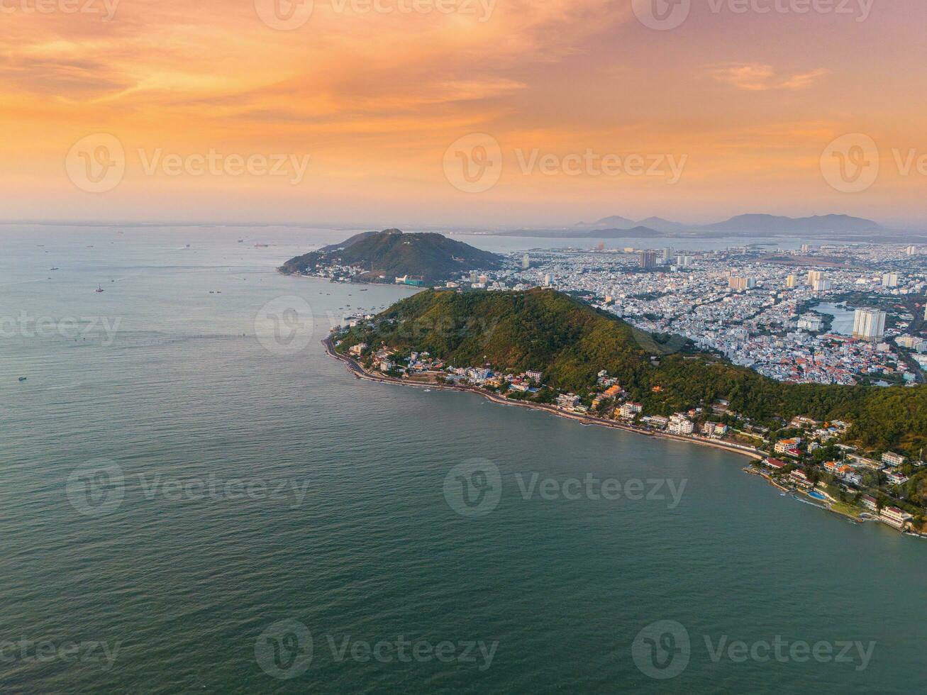 Panoramic coastal Vung Tau view from above, with waves, coastline, streets, coconut trees, Mount Nho in Vietnam behind the statue of Christ the King photo