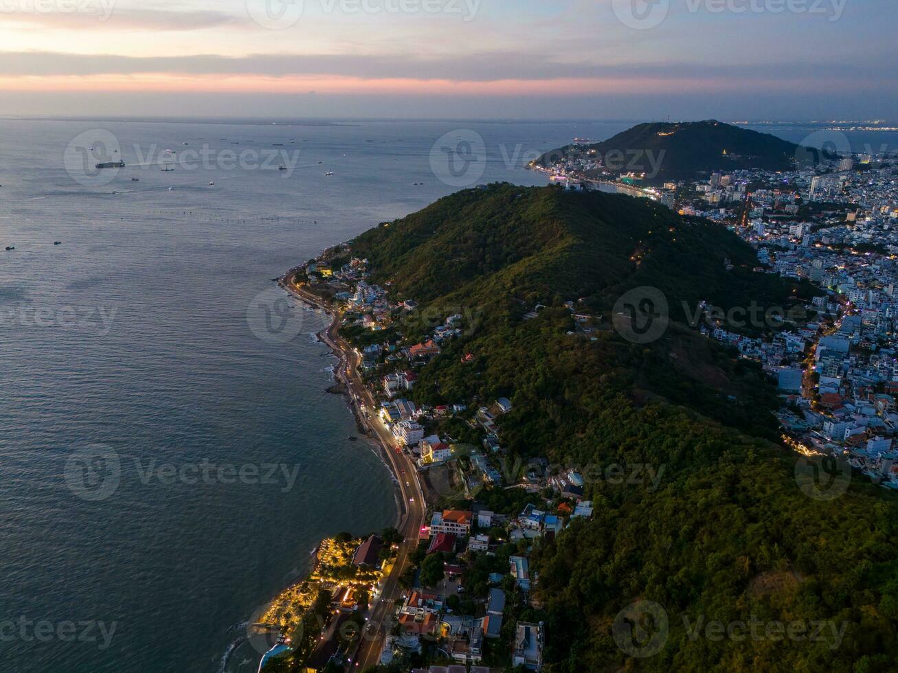 Panoramic coastal Vung Tau view from above, with waves, coastline, streets, coconut trees, Mount Nho in Vietnam behind the statue of Christ the King photo