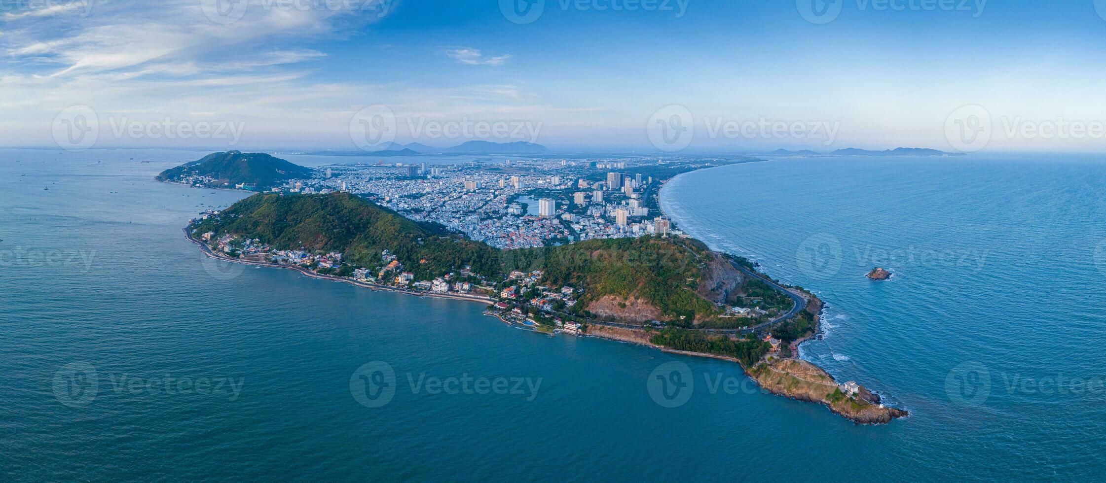 Panoramic coastal Vung Tau view from above, with waves, coastline, streets, coconut trees, Mount Nho in Vietnam behind the statue of Christ the King photo