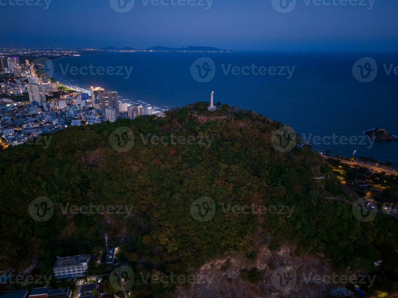 Panoramic coastal Vung Tau view from above, with waves, coastline, streets, coconut trees, Mount Nho in Vietnam behind the statue of Christ the King photo
