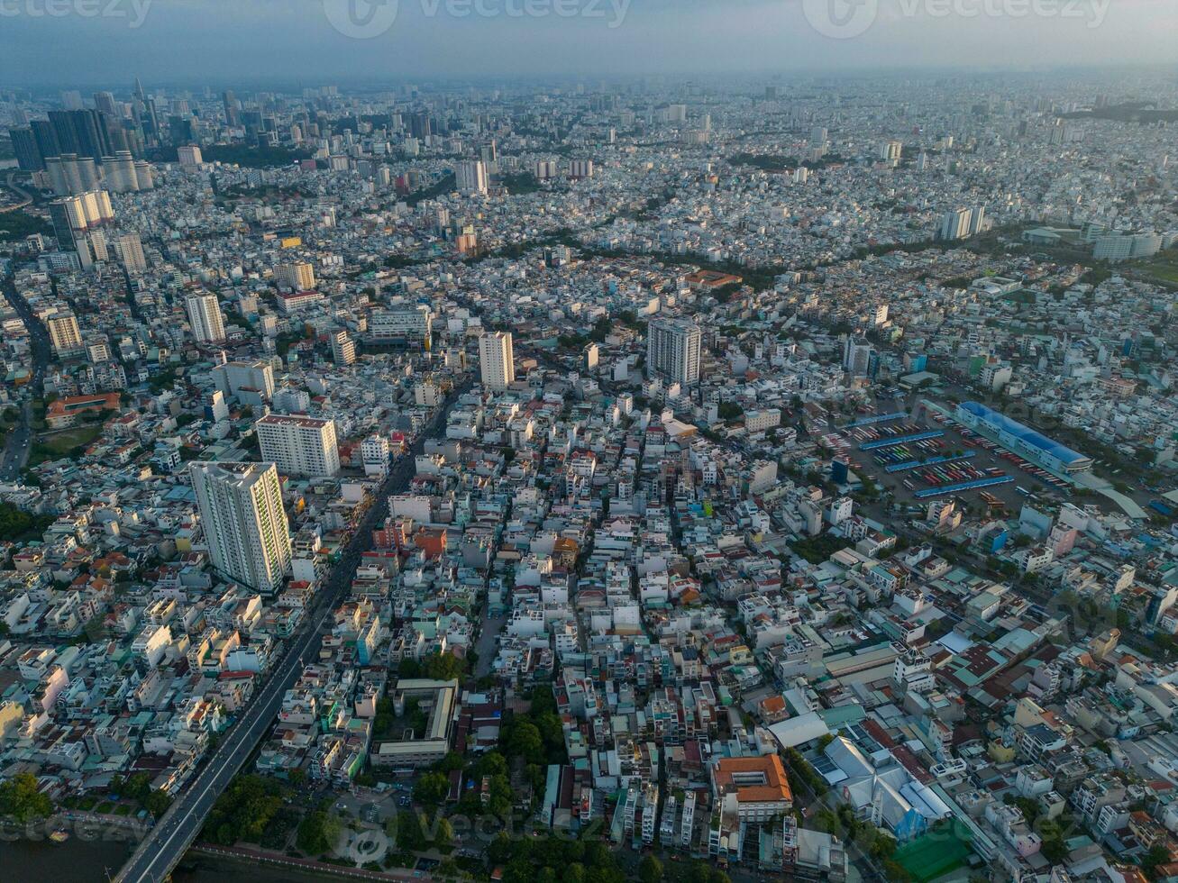 Panoramic view of Saigon, Vietnam from above at Ho Chi Minh City's central business district. Cityscape and many buildings, local houses, bridges, rivers photo