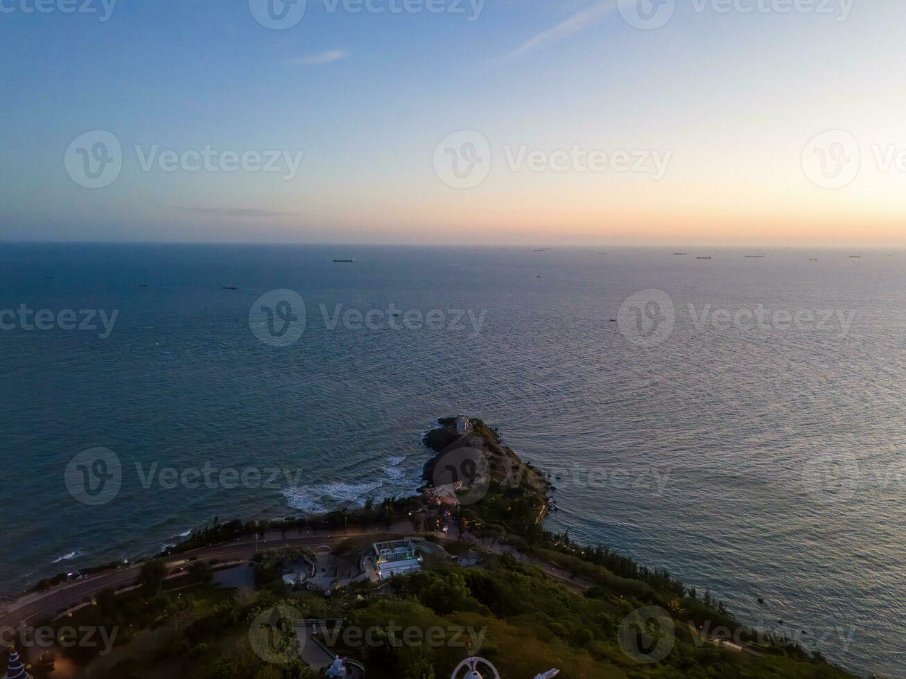 Panoramic coastal Vung Tau view from above, with waves, coastline, streets, coconut trees, Mount Nho in Vietnam behind the statue of Christ the King photo