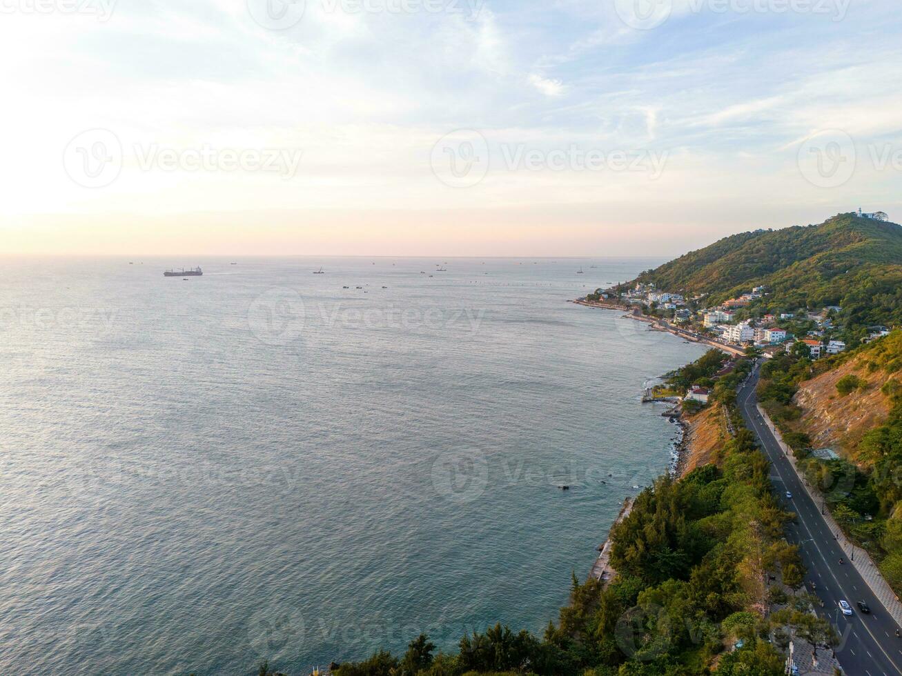 Panoramic coastal Vung Tau view from above, with waves, coastline, streets, coconut trees, Mount Nho in Vietnam behind the statue of Christ the King photo