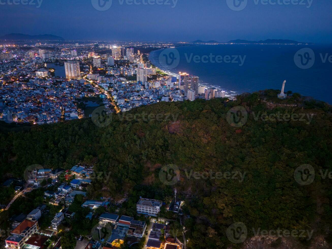 Panoramic coastal Vung Tau view from above, with waves, coastline, streets, coconut trees, Mount Nho in Vietnam behind the statue of Christ the King photo