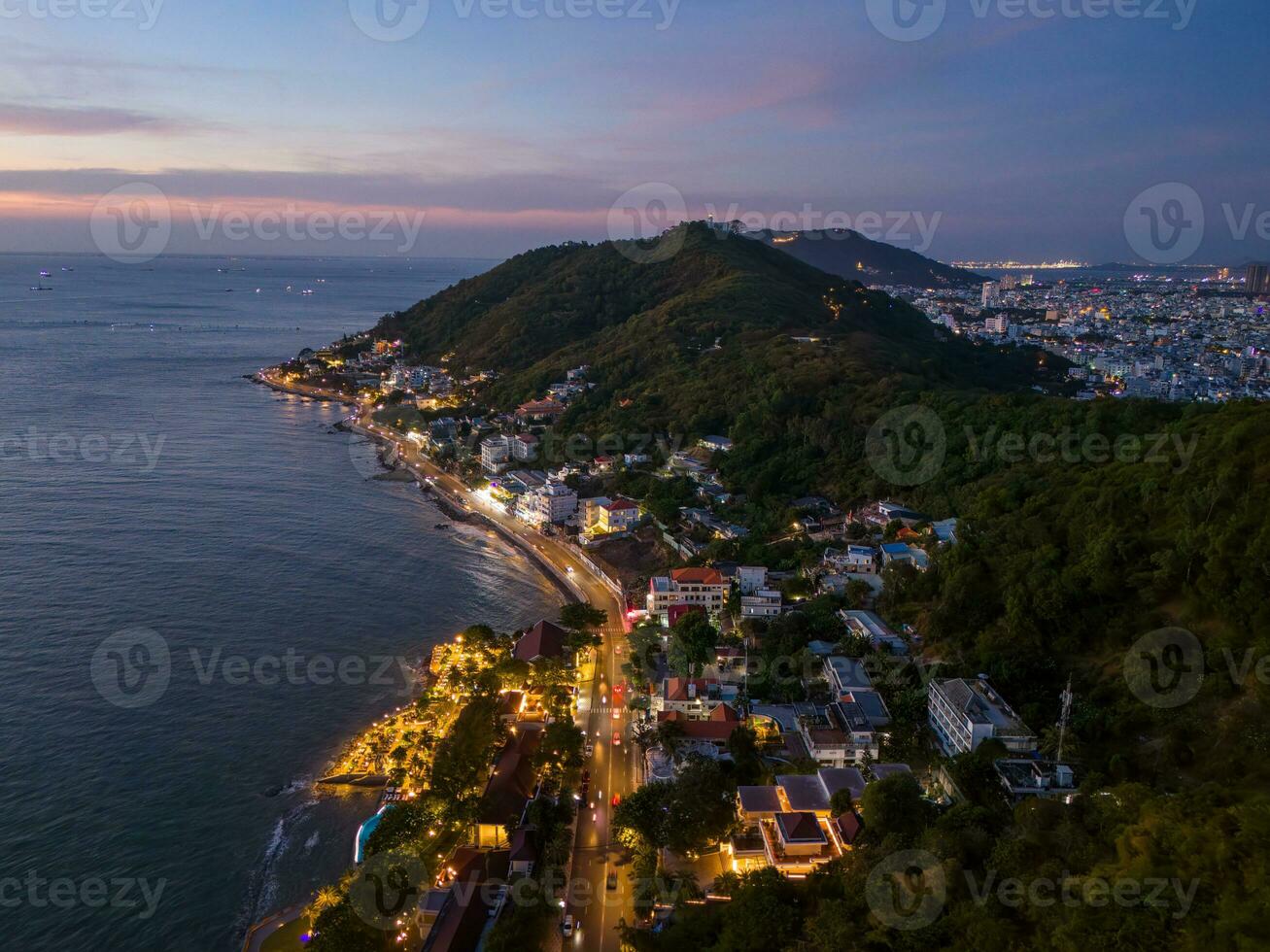 Panoramic coastal Vung Tau view from above, with waves, coastline, streets, coconut trees, Mount Nho in Vietnam behind the statue of Christ the King photo