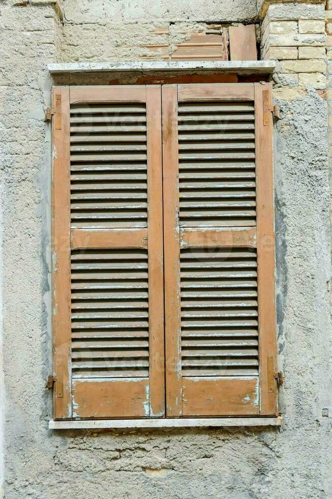 old window with shutters on a stone wall photo