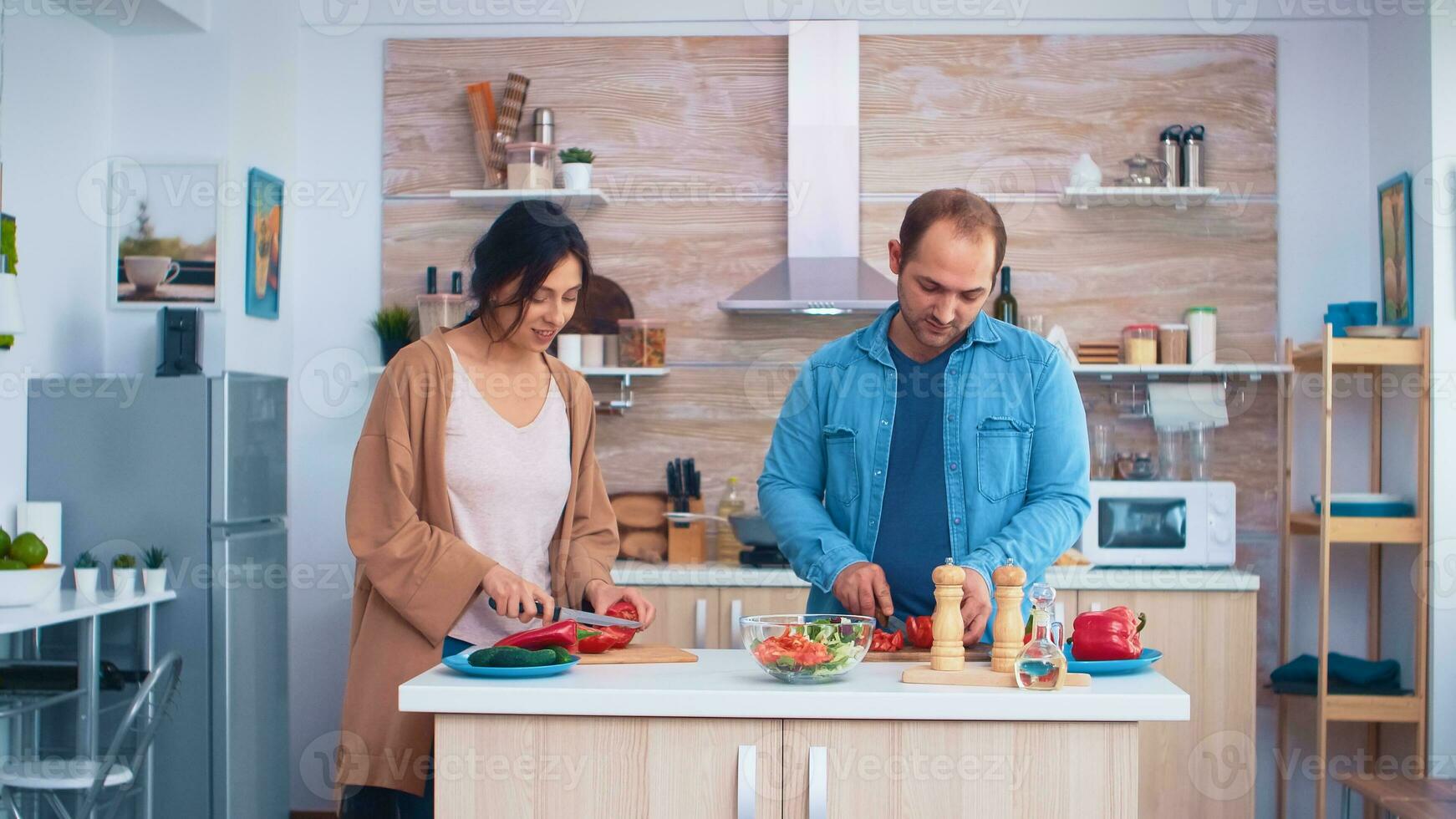 Pareja corte Fresco vegetales para sano ensalada en cocina utilizando agudo cuchillos Cocinando preparando sano orgánico comida contento juntos estilo de vida. alegre comida en familia con vegetales foto