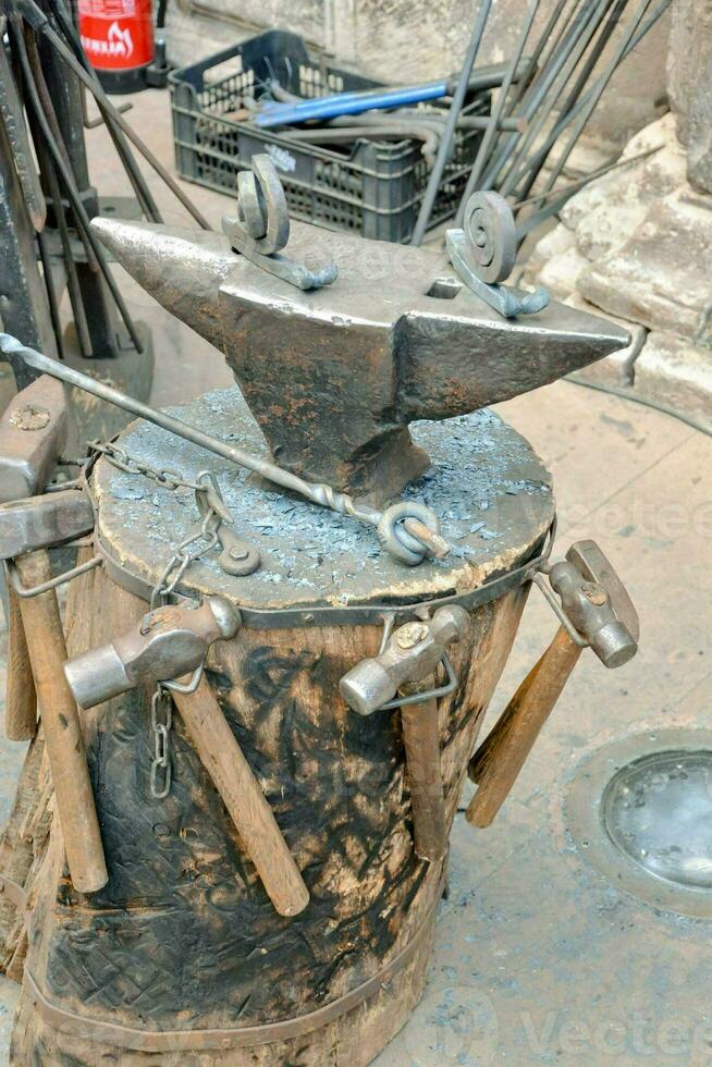 an old blacksmith's anvil with a hammer and other tools photo