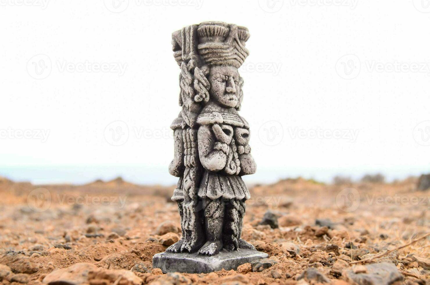 a statue of a man standing on top of a rock photo