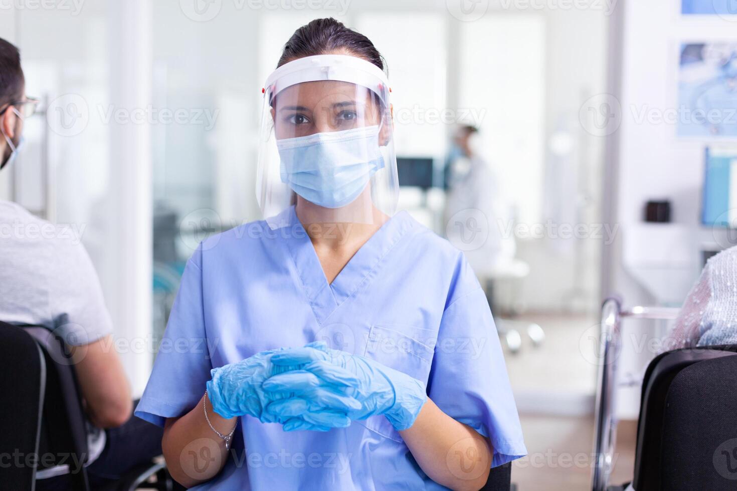 Medical staff in waiting area of hospital wearing surgical face mask as safety precaution against coronavirus global pandemic., Physician, epidemic, care, surgical, corridor. photo