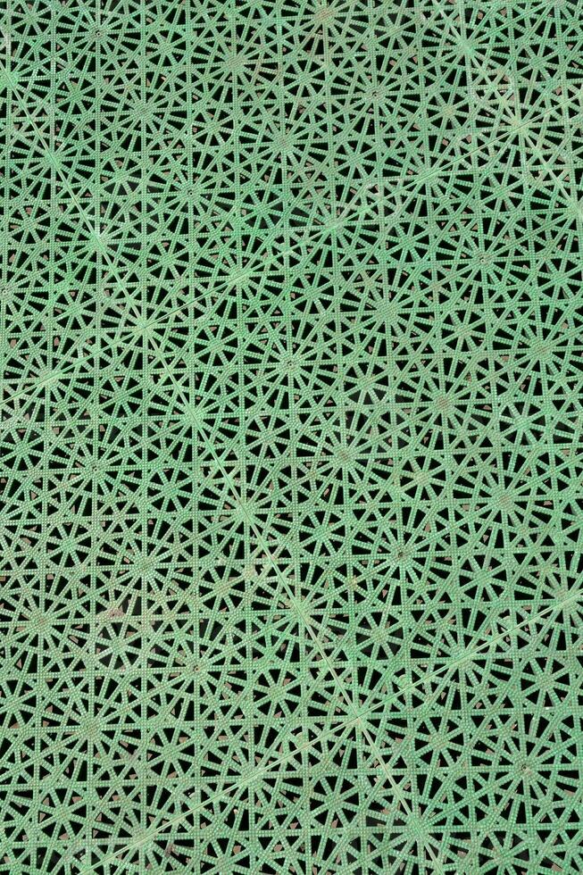 a green patterned surface with holes in it photo
