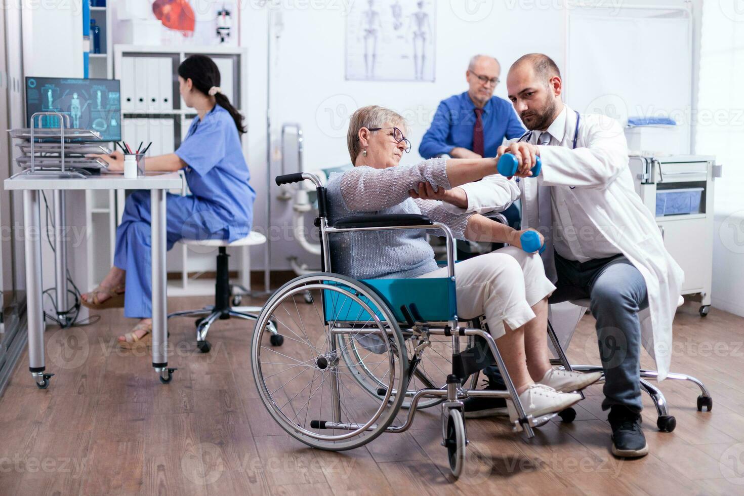 Disabled woman doing recovery with dumbbells and help from doctor in hospital. Man with disabilities ,walking frame sitting in hospital bed. Health care system, patients. photo