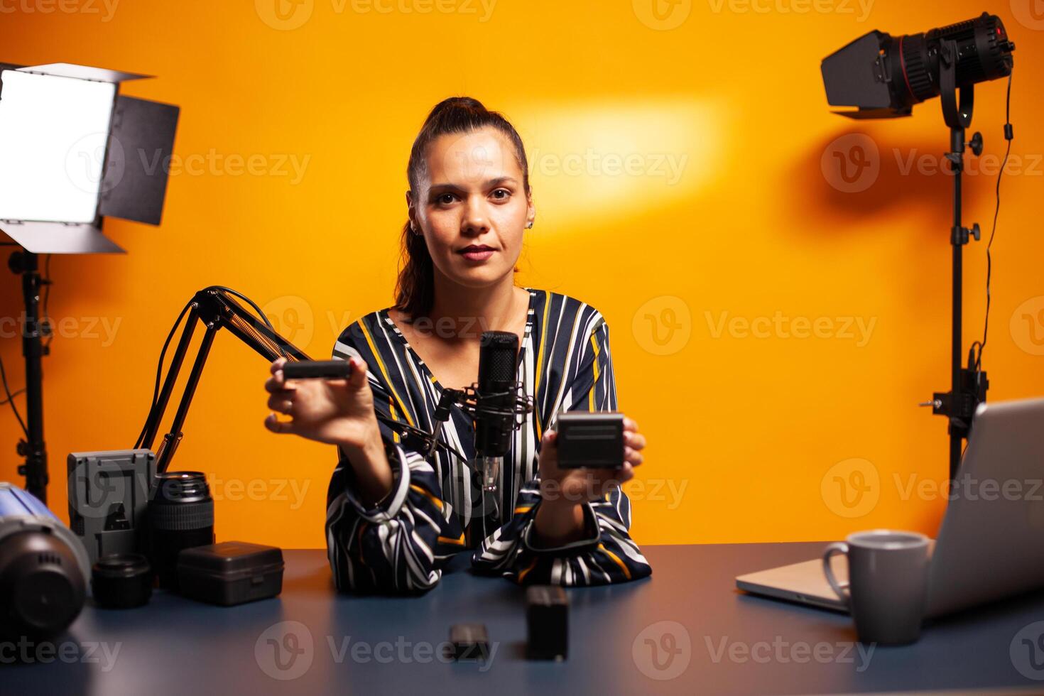 Testing batteries for camera during podcast in home studio. Presenting review studio portable testing modern batteries li-ion accessory device modern lighting technology. photo