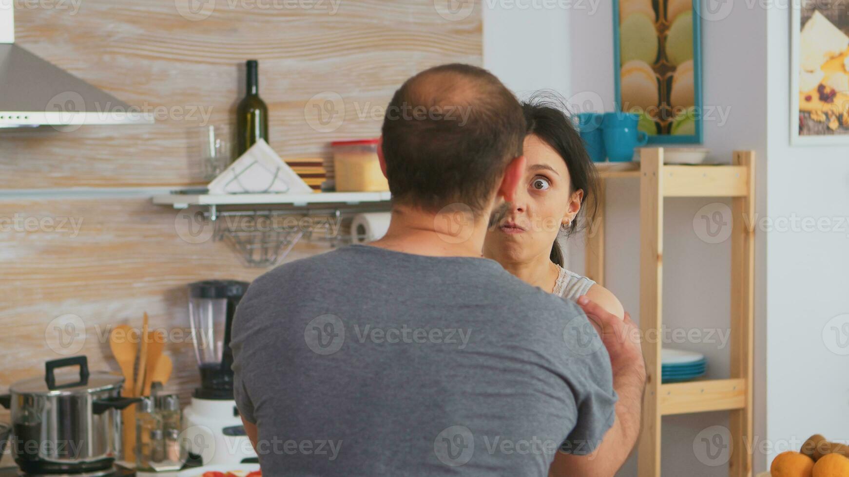 Frightened defenseless wife covering face in fear from aggressive husband. Domestic violence threatening aggressive angry frustrated husband abusing physical depressed sad unhappy crying stressed woman. Home abuse photo