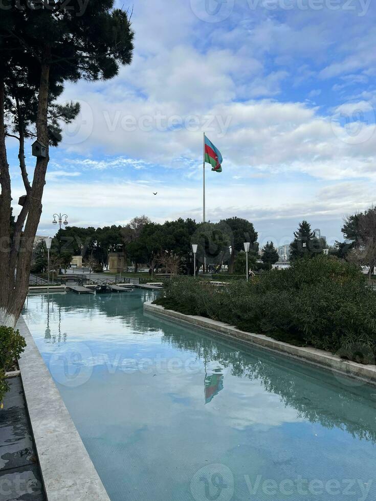 AI generated park with pool and azerbaijan flag waving in cloudy weather photo