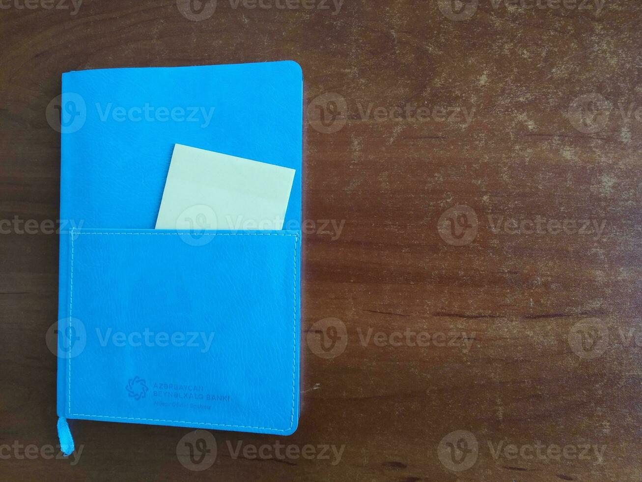 AI generated Blue notebook on wooden background. Top view. Copy space for text photo