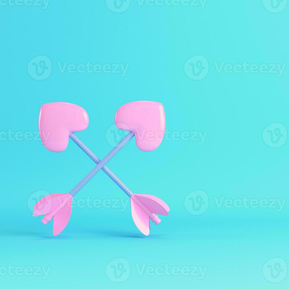 Pink two crossed cupid arrows on bright blue background in pastel colors photo