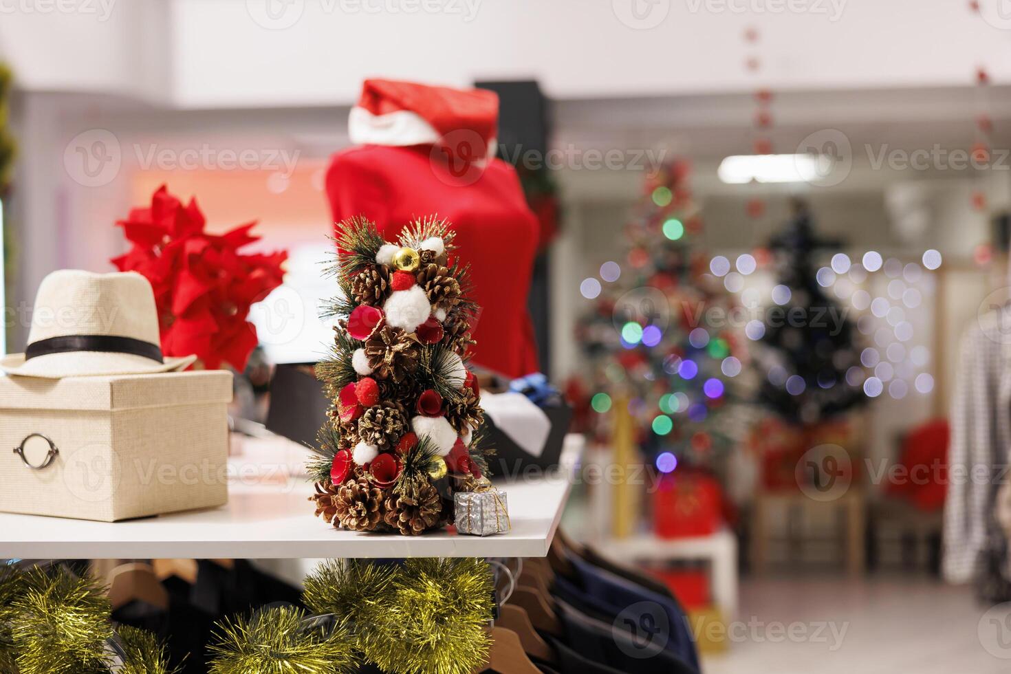 Festive Christmas decorated store with variety of clothing on sale for holiday gift shopping. Mall outlet with clothes, xmas ornaments and formal attire inside retail shop during seasonal holiday. photo