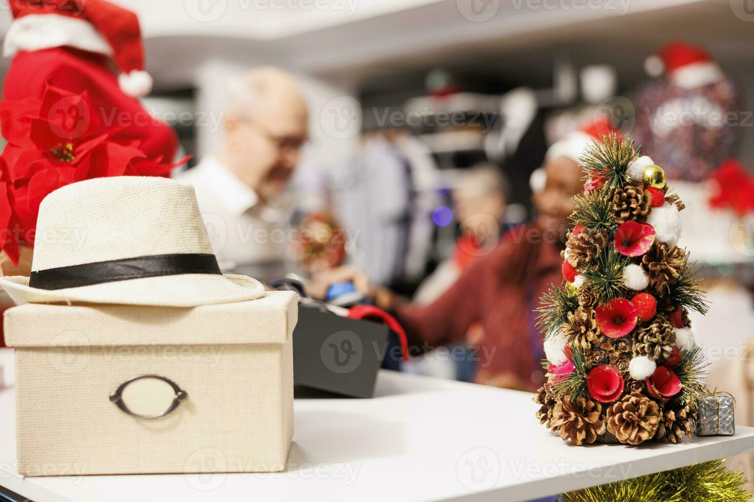 Selective focus of people checking clothes in shopping center boutique, retail store assistant helping elder client to choose items for christmas gifts. Diverse man and woman talking about fabrics. photo