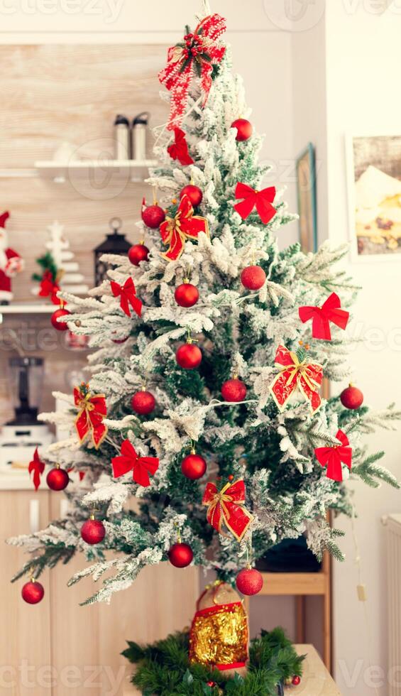 Beautiful decorated christmas tree in empty kitchen. Kitchen on christmas day with nobody in the room decorated with x-mas tree and garlands photo