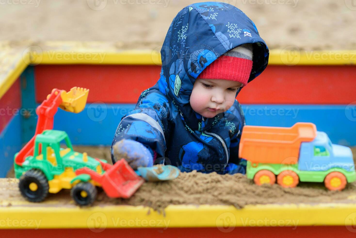 the child plays cars on the playground photo
