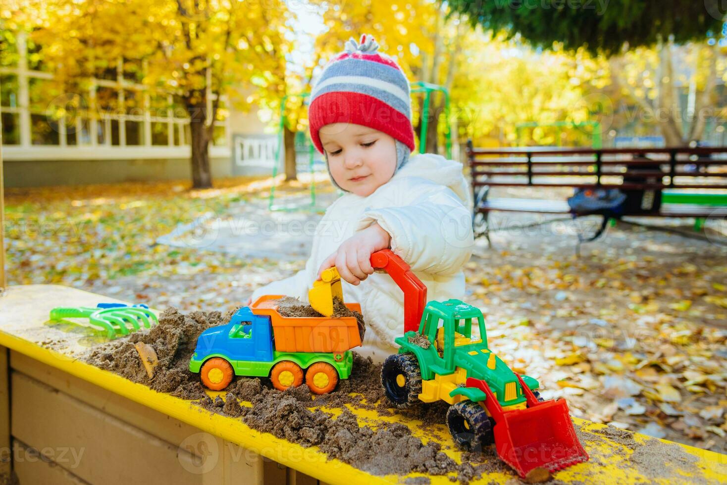 the child plays cars on the playground photo