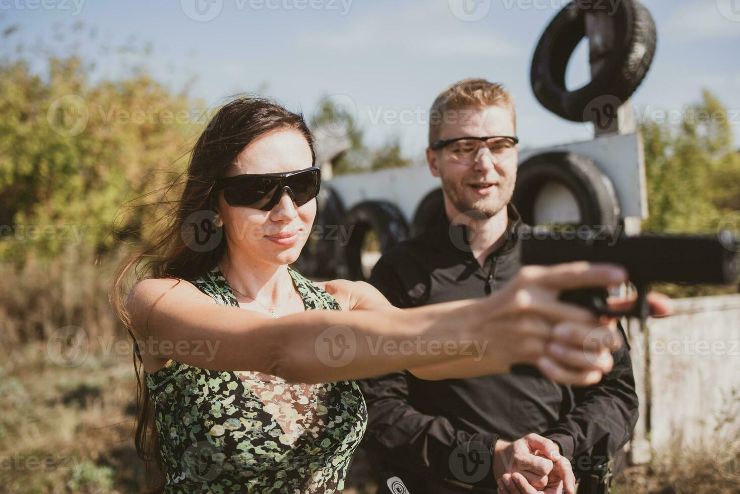 A girl learns to shoot a pistol at a shooting range with an instructor photo