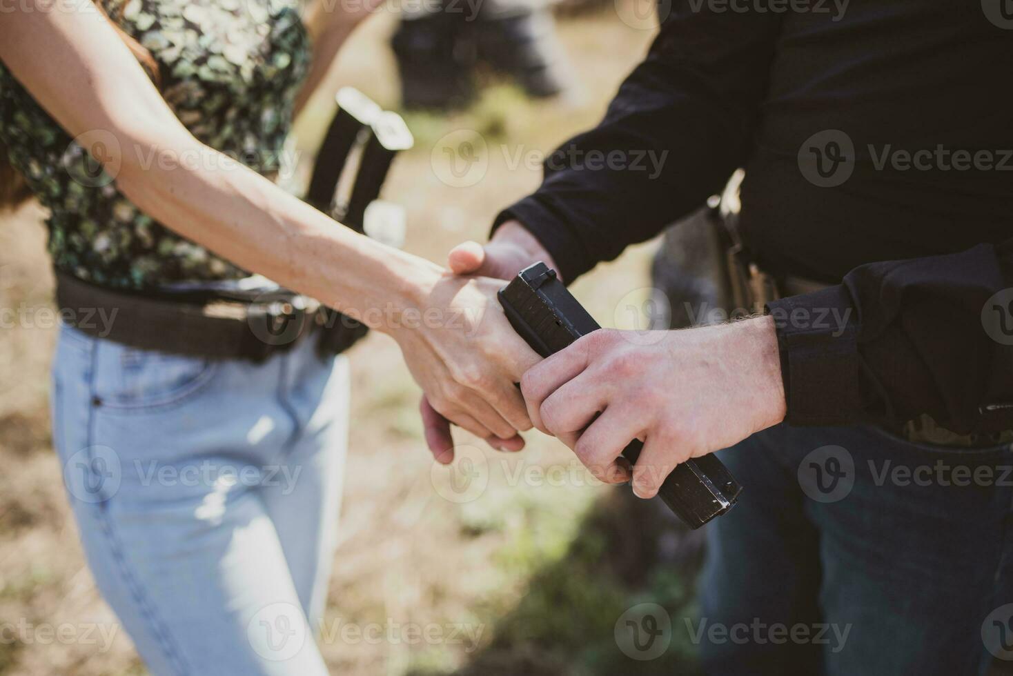 A girl learns to shoot a pistol at a shooting range with an instructor photo