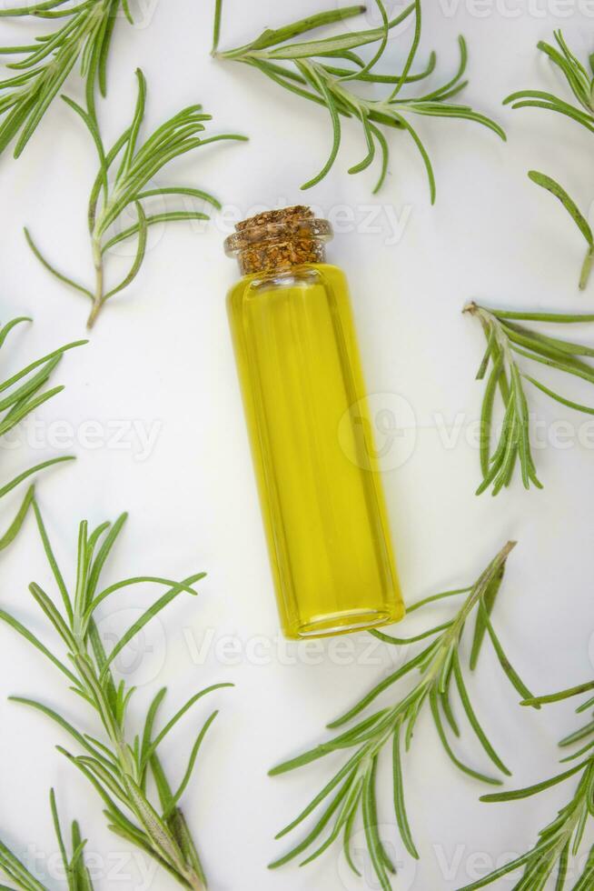 Rosemary oil and fresh rosemary on a white towel. photo