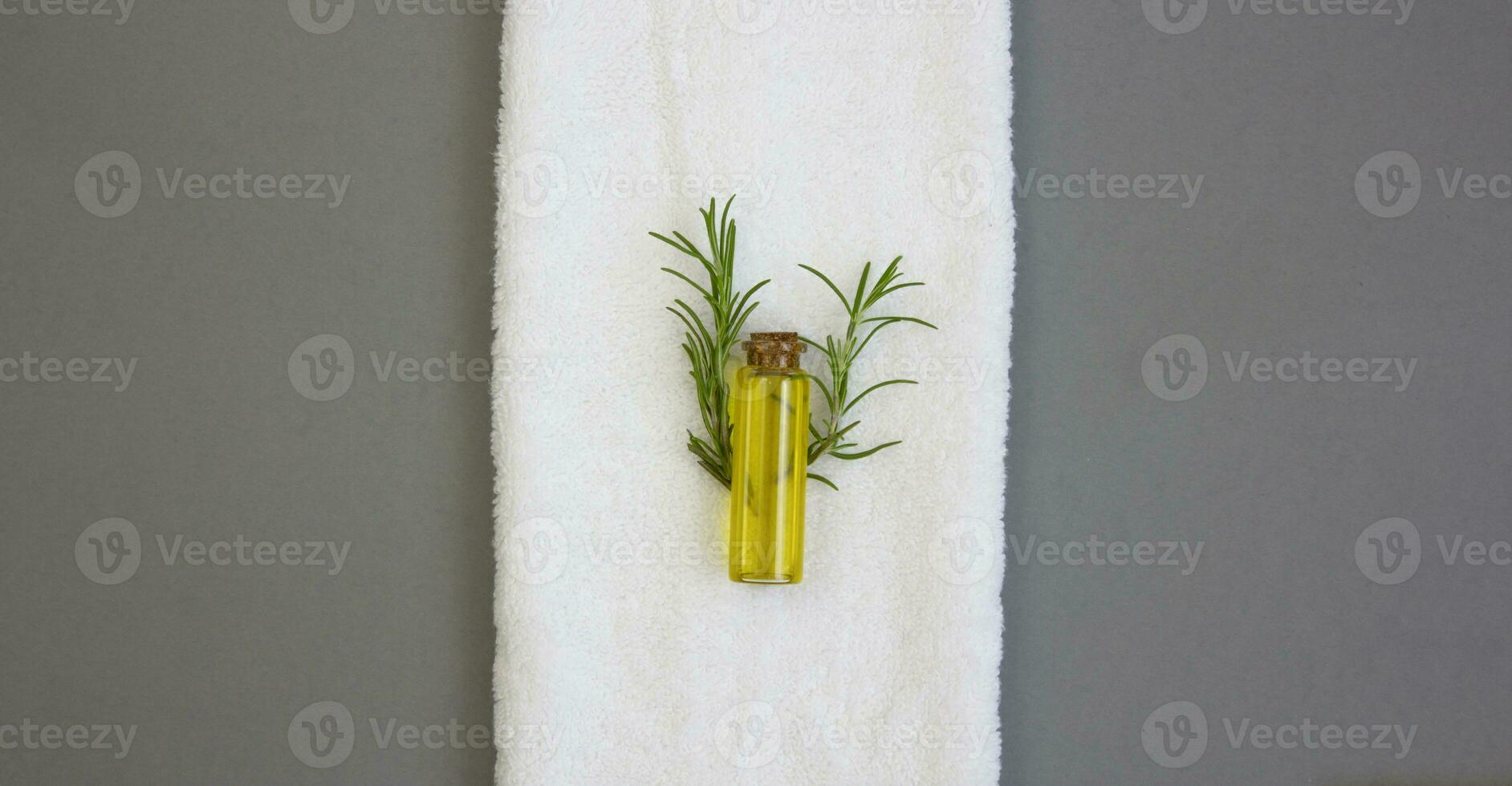 Rosemary oil on a white towel. Natural cosmetics for body and hair care. photo