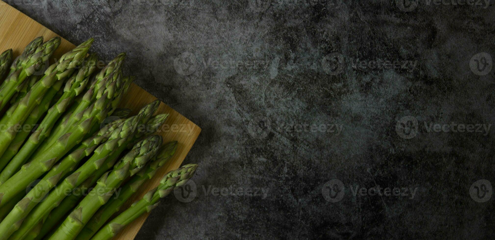 verde espárragos en un oscuro Roca fondo, cerca arriba foto