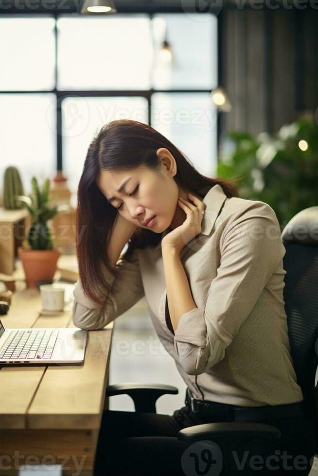 AI generated Young tired Asian woman with neck pain sits at the computer. Sad, unhappy, worried, depressed or stress concept in employee life photo