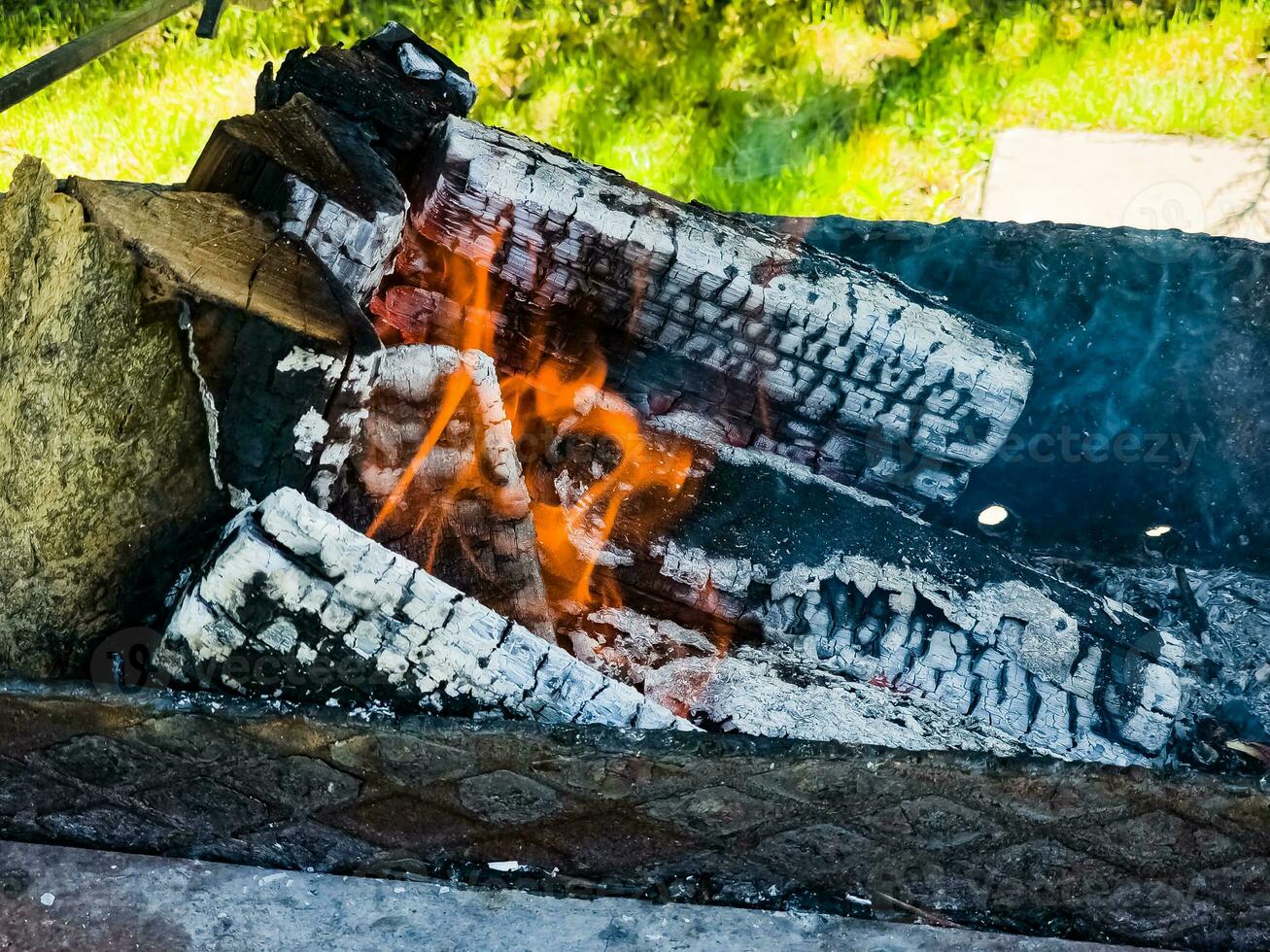 Close-up of a fire with firewood, coals and ashes. photo