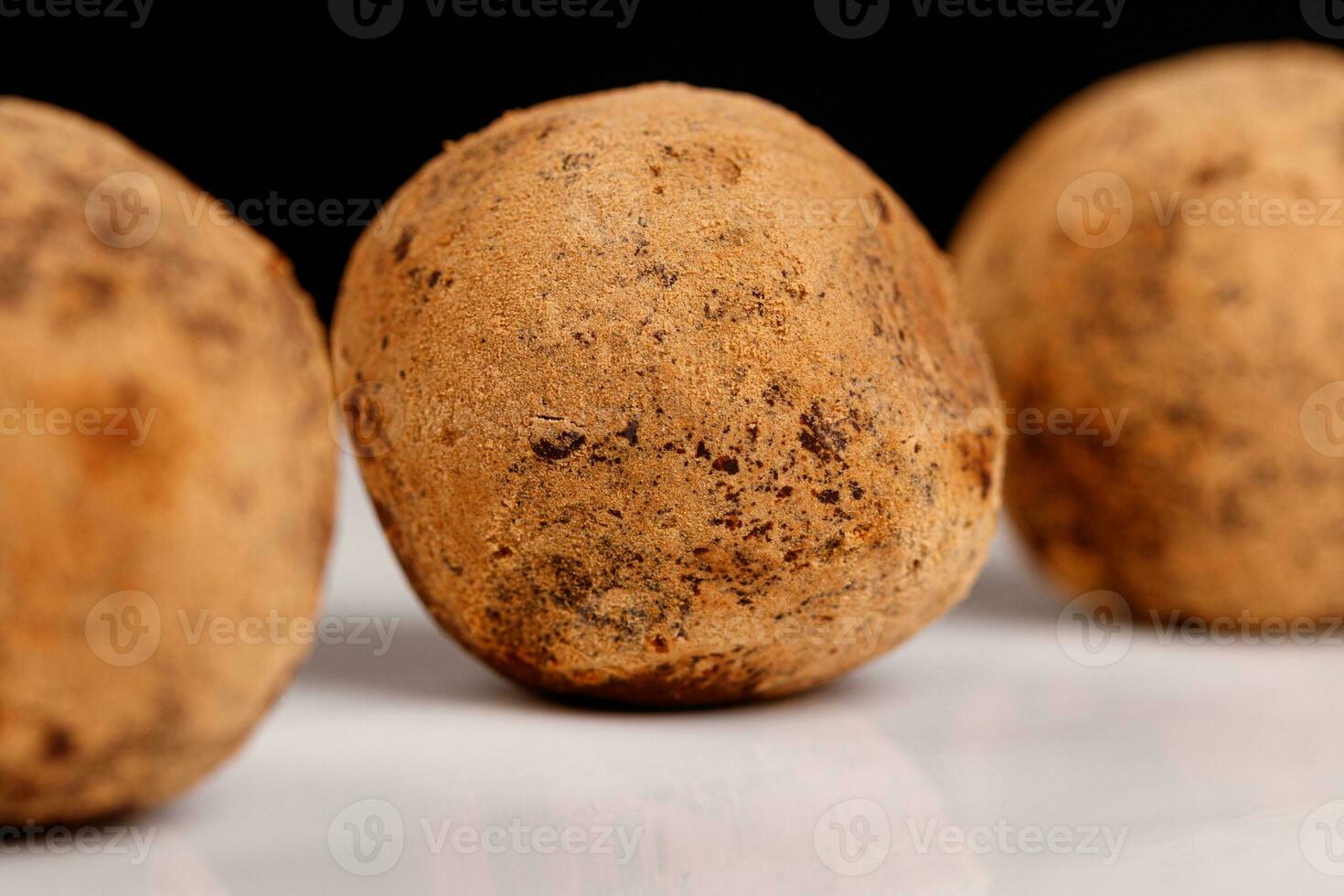 Beautiful candy truffle on a white plate on a black background photo