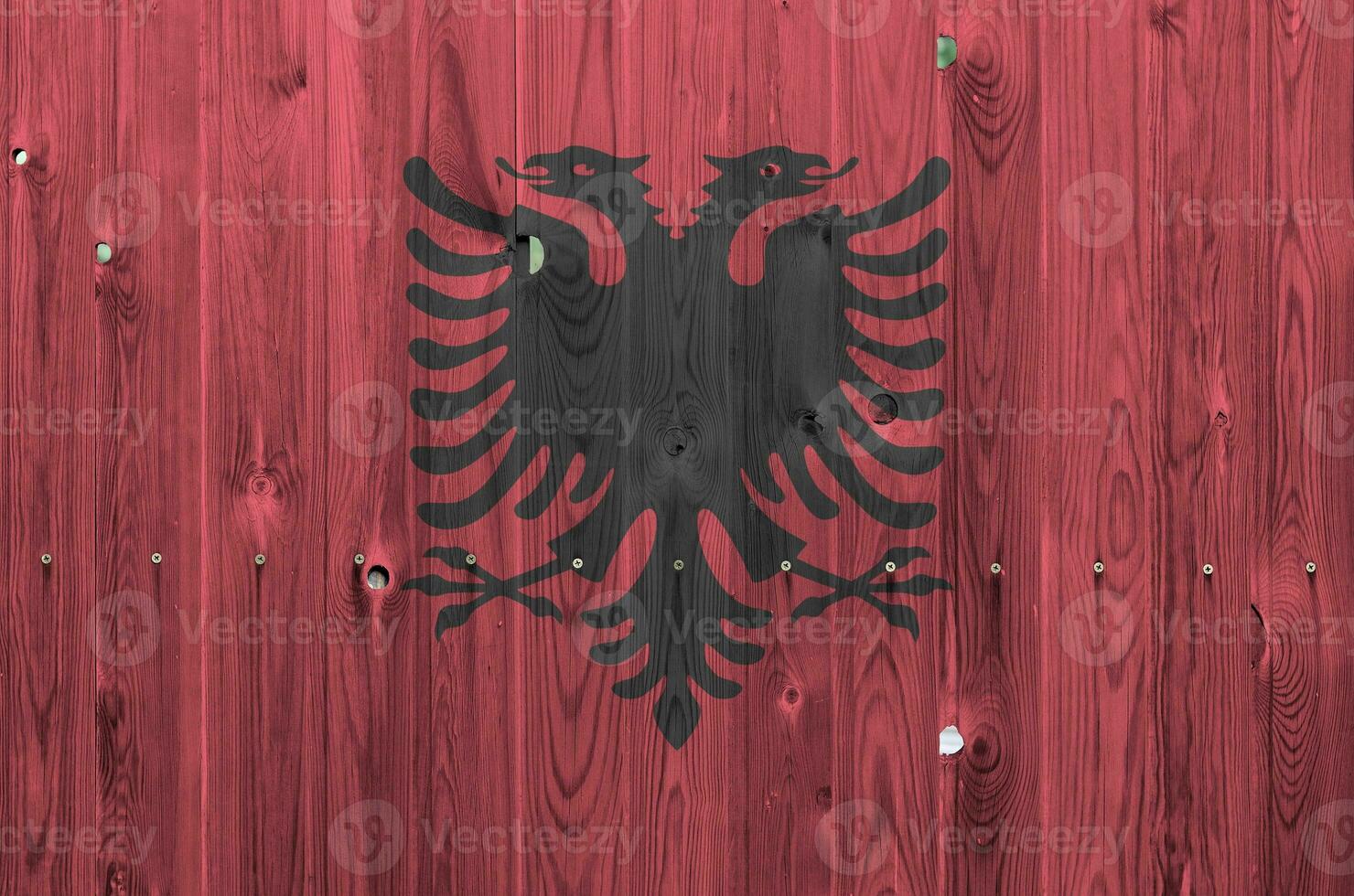 Albania flag depicted in bright paint colors on old wooden wall. Textured banner on rough background photo