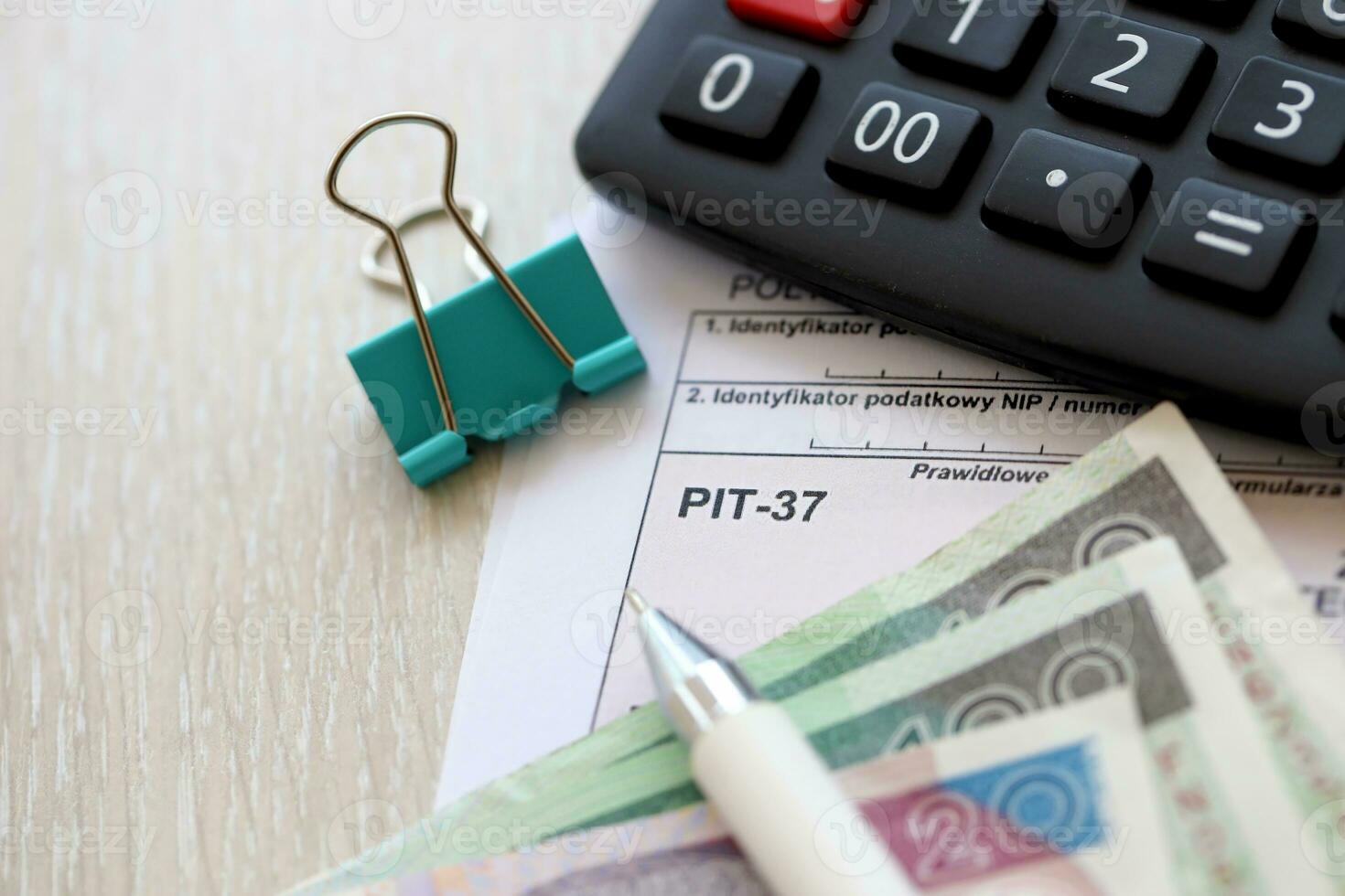 Declaration of the amount of earned income or incurred loss PIT-37 tax forms on accountant table with pen and polish zloty money bills photo