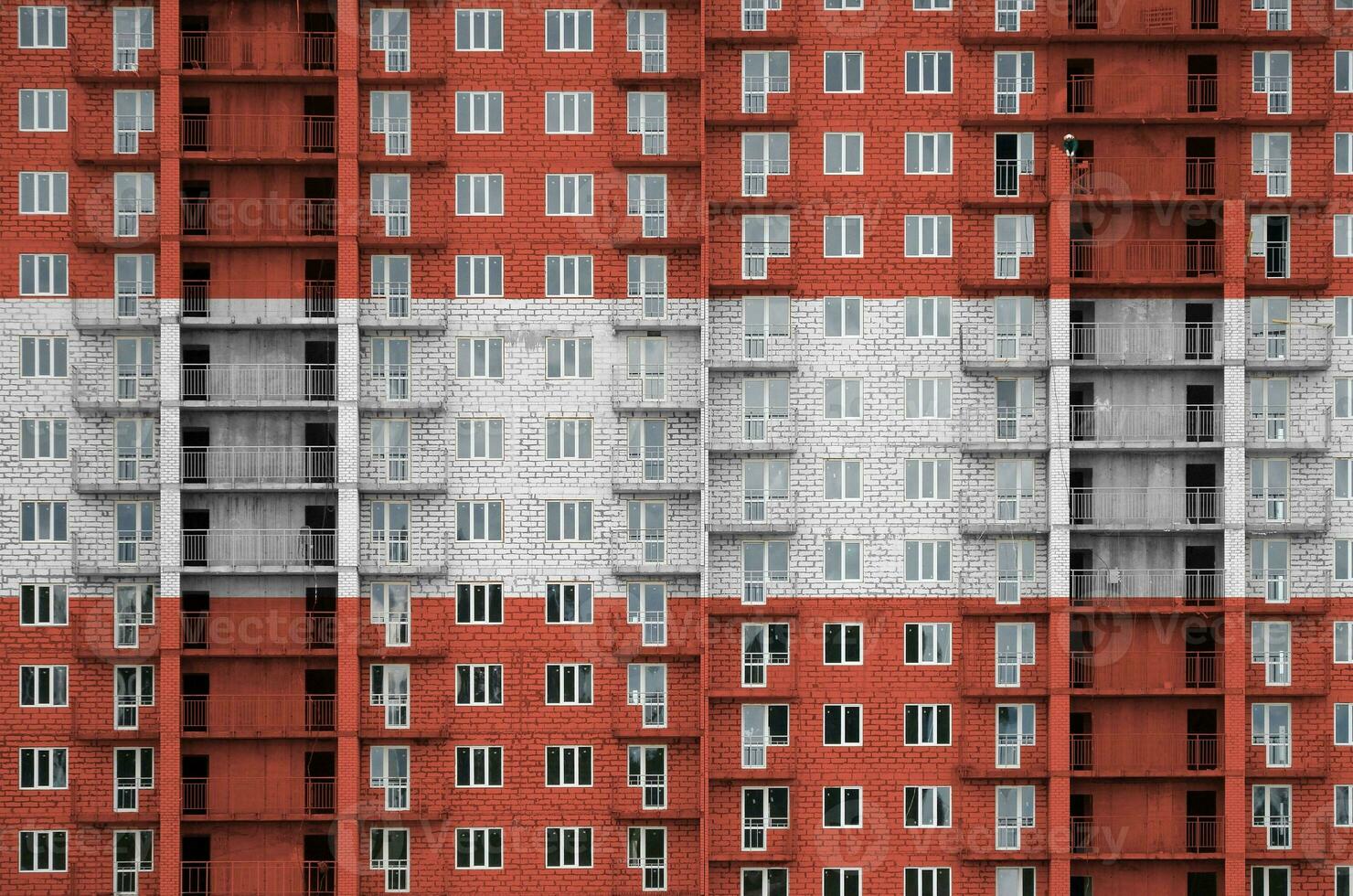 Austria flag depicted in paint colors on multi-storey residental building under construction. Textured banner on brick wall background photo