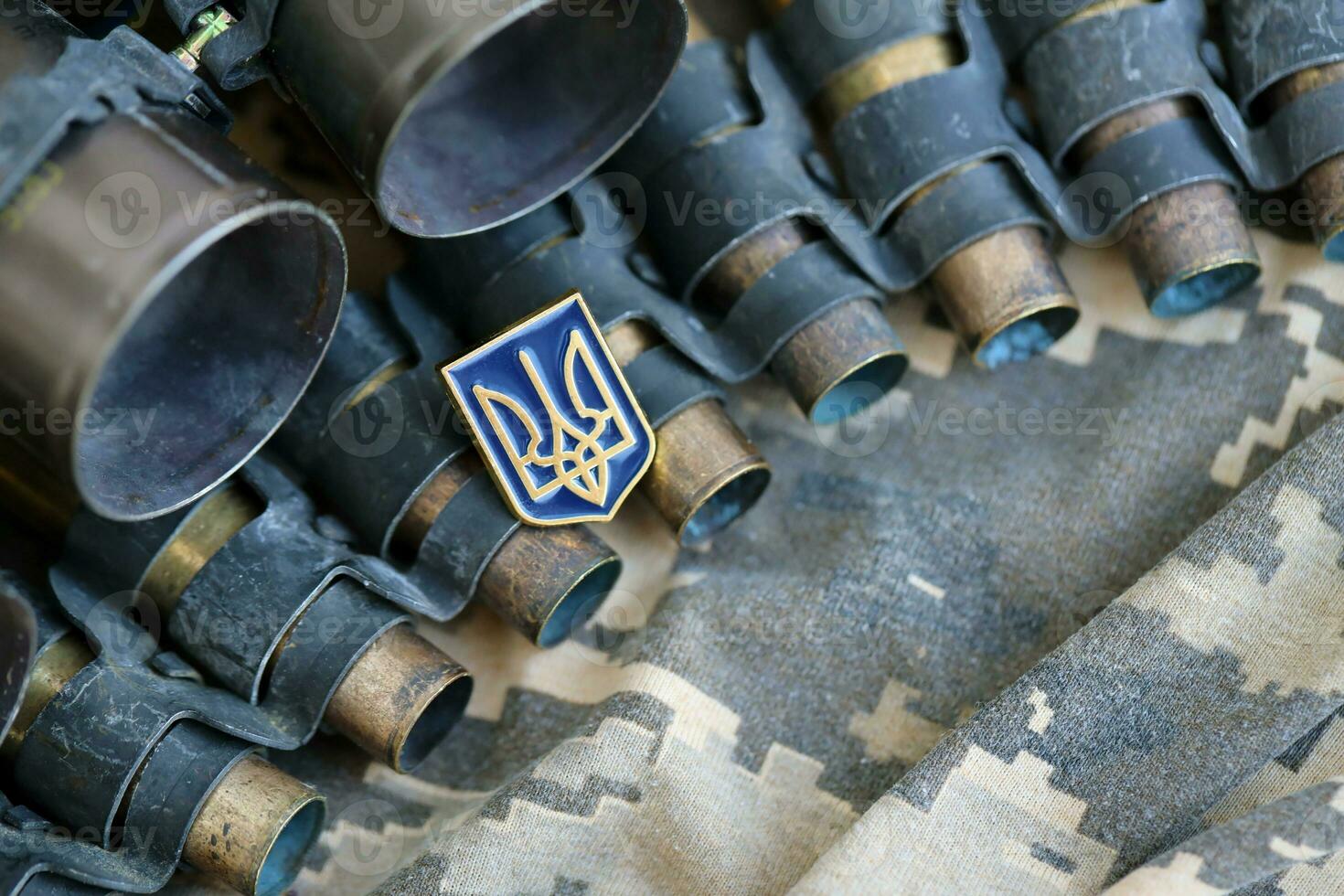 Ukrainian symbol on machine gun belt lies on ukrainian pixeled military camouflage photo