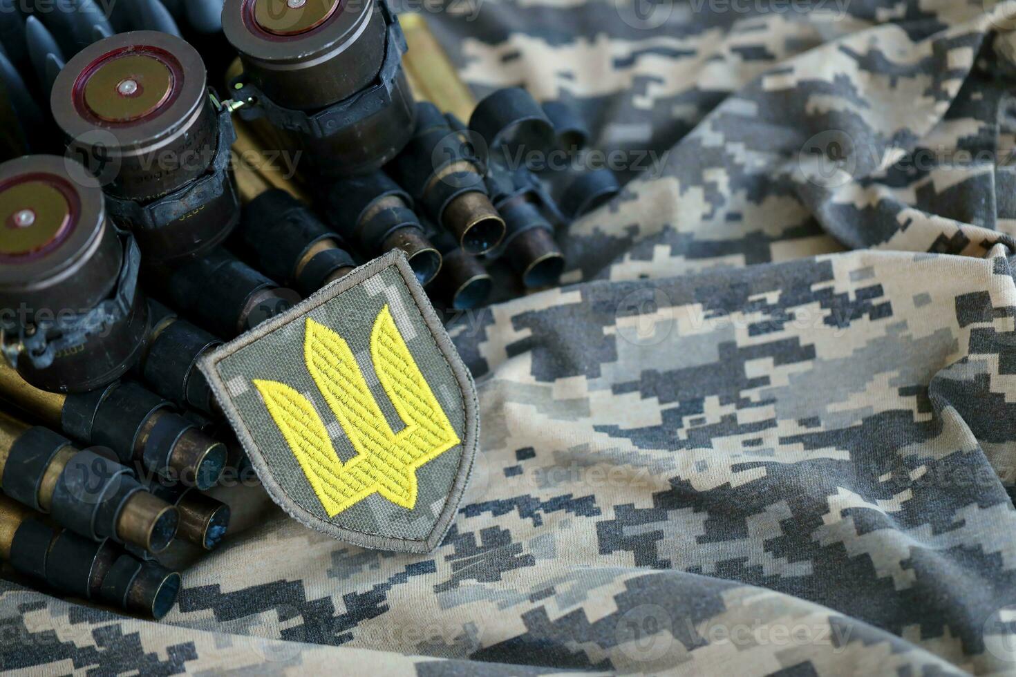 Ukrainian army symbol on machine gun belt lies on ukrainian pixeled military camouflage photo