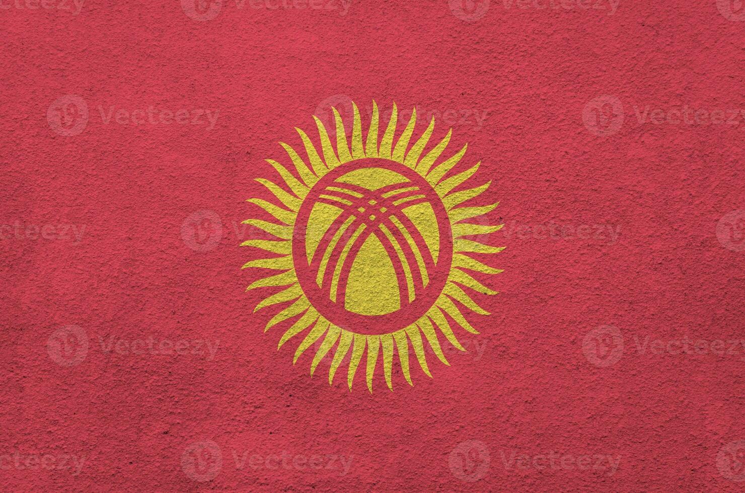 Kyrgyzstan flag depicted in bright paint colors on old relief plastering wall. Textured banner on rough background photo