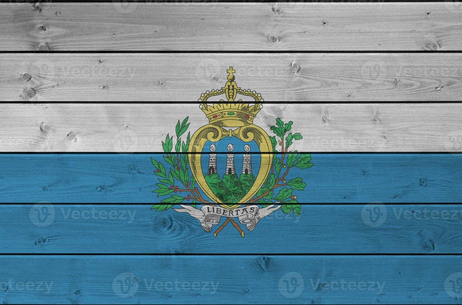 San Marino flag depicted in bright paint colors on old wooden wall. Textured banner on rough background photo