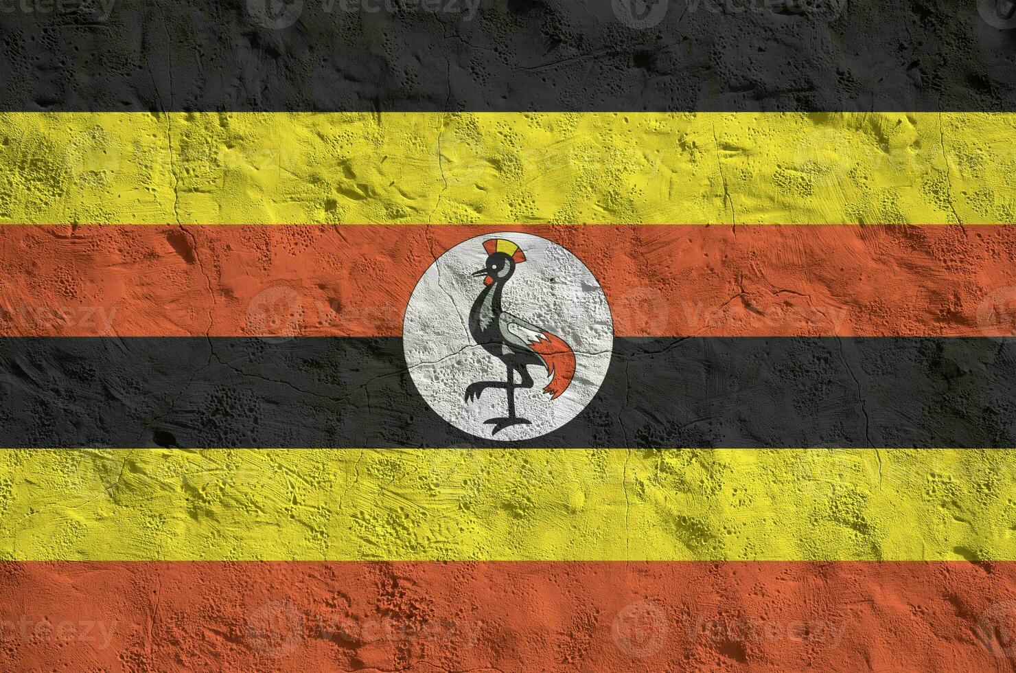 Uganda flag depicted in bright paint colors on old relief plastering wall. Textured banner on rough background photo