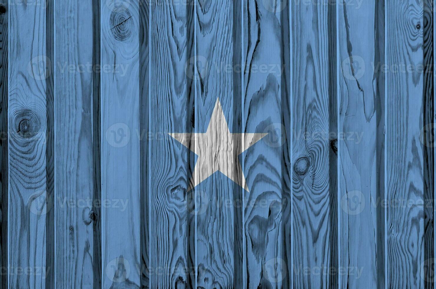 Somalia flag depicted in bright paint colors on old wooden wall. Textured banner on rough background photo