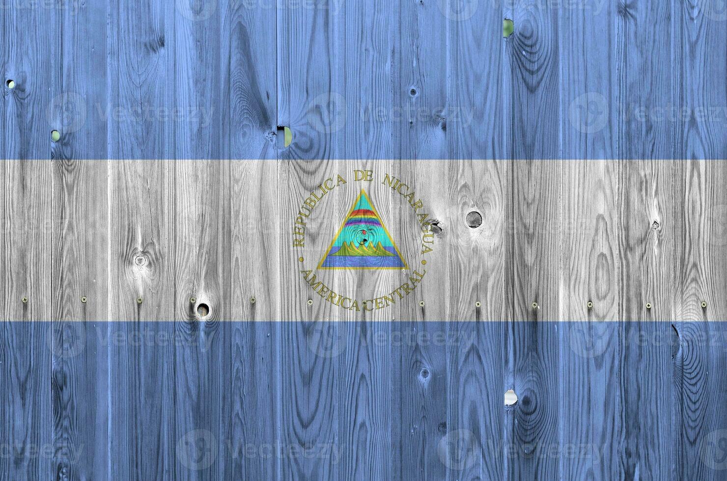 Nicaragua flag depicted in bright paint colors on old wooden wall. Textured banner on rough background photo