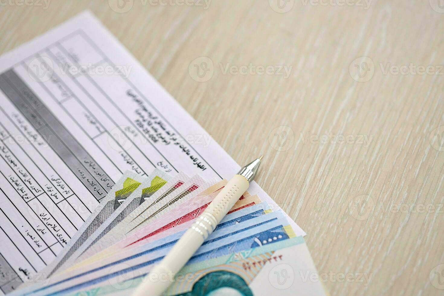 Iranian annual income tax return form F20-25-006 ready to fill on table with iranian money photo