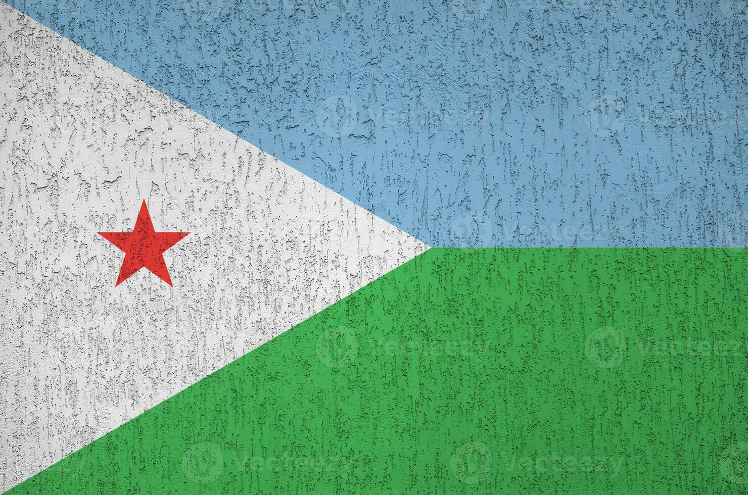 Djibouti flag depicted in bright paint colors on old relief plastering wall. Textured banner on rough background photo